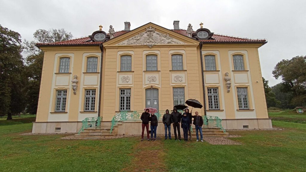 7 osób; 3 trzymają parasole