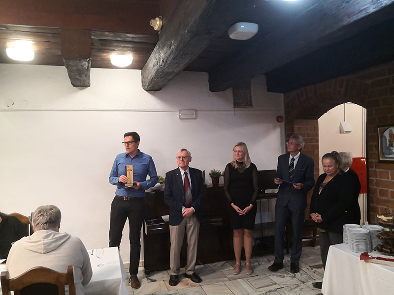 Pierwszy od lewej dr T. Panecki trzymający nagrodę; po jego lewej 4 inne osoby